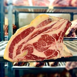 A thick, beautifully marbled cut of 45 Days Dry Aged Rubia Gallega Prime Ribs, ready for cooking.