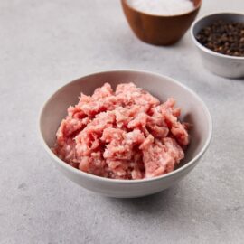 A close-up of fresh, vibrant free-range pork minced, ready for cooking.