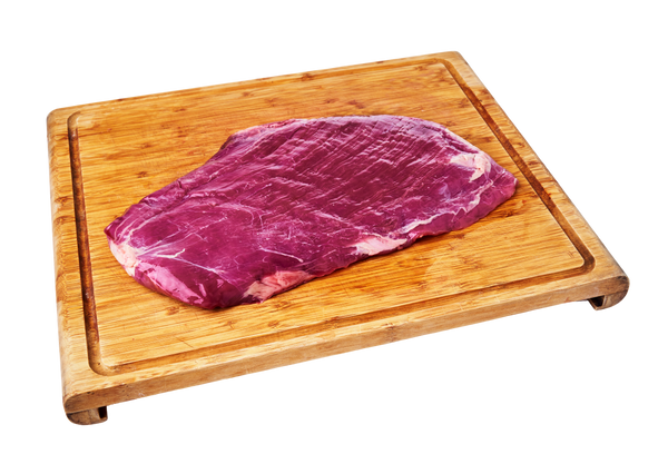 A premium, lean cut of grass-fed beef flank steak, deep red in color, ready for preparation.