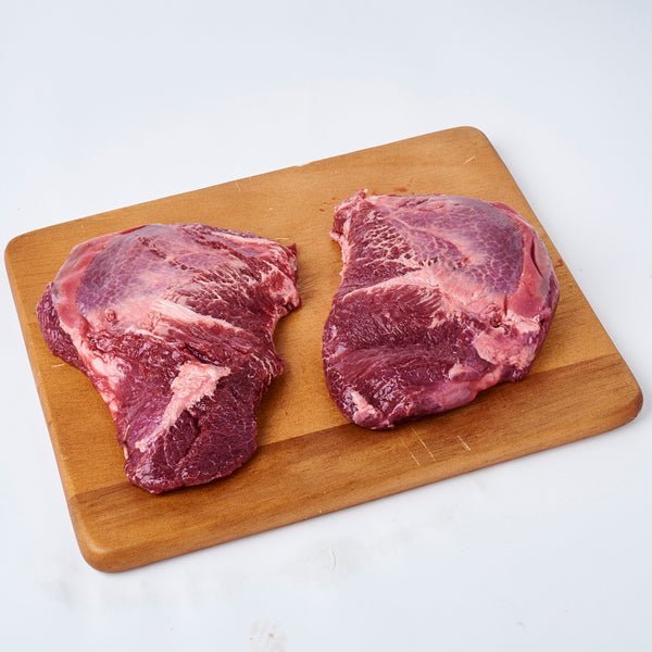 Expertly trimmed, raw grassfed free range beef cheeks, deep red in color, ready for slow cooking.