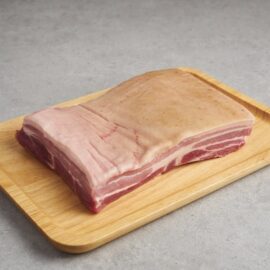 Premium pork belly with skin on, showing distinct layers of meat and creamy white fat.