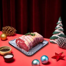 A beautifully tied Christmas Grassfed Ribeye Roast, uncooked and ready for the oven, showcasing its rich red color and marbling.