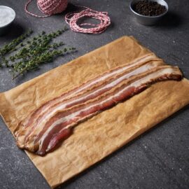 Slices of premium Dingley Dell Beer & Treacle Streaky Bacon, perfectly marbled and ready to cook.