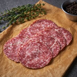 Slices of premium Dingley Dell Milano Salami arranged on a charcuterie board showing its fine texture.