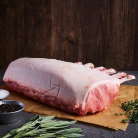 A beautifully prepared Dingley Dell Pork Rack French Cut, ready for roasting, showcasing the clean bones and rich marbling.