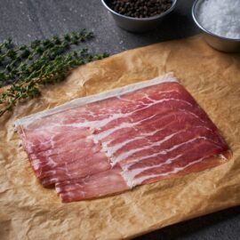 Paper-thin slices of Dingley Dell Prosciutto Ham arranged beautifully on a wooden board.