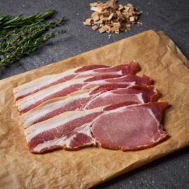 A close-up of beautifully smoked, thick-cut Dingley Dell back bacon slices, showcasing their rich color and meaty texture.