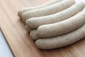 A close-up of perfectly grilled beef bratwurst sausages on a platter, ready to be served.