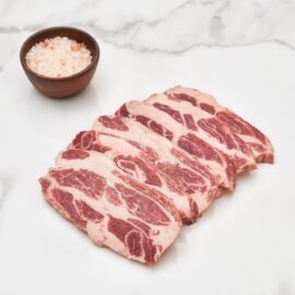 A close-up of a raw, richly marbled cut of Frozen Iberico Pork Collar, showcasing its deep red color and intricate fat veins.