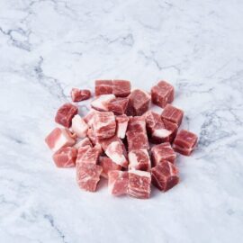 Close-up of perfectly cut frozen pork collar cubes with visible marbling, ready for cooking.