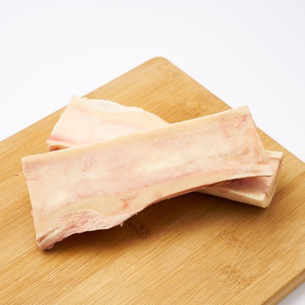 Roasted Grassfed Beef Bone Marrow in Canoe and Center cuts, showing a rich, creamy texture on a wooden board.
