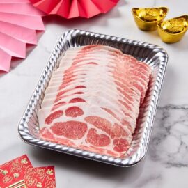 Paper-thin slices of beautifully marbled Kurobuta Pork Collar Shabu fanned out on a black plate, ready for cooking.