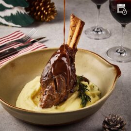A perfectly cooked Lamb Shank with a rich Red Wine Jus sauce, ready to serve.