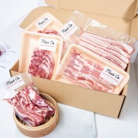 An assortment of premium frozen pork cuts from the Pork Freezer Essential Pack, including steaks, mince, and sliced belly.