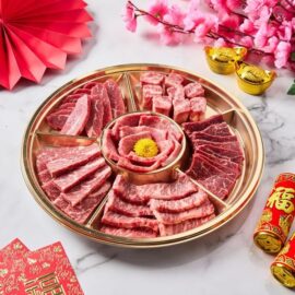 A beautifully arranged Prosperity Beef Yakiniku Platter with various cuts of marbled beef ready for grilling.
