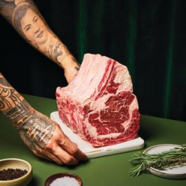 A magnificent, perfectly cooked USDA Choice Prime Rib Roast, sliced to reveal a juicy pink center, ready to be served.